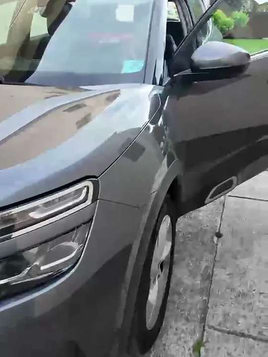 Bok tmavého Citroënu zaparkovaného na chodníku
