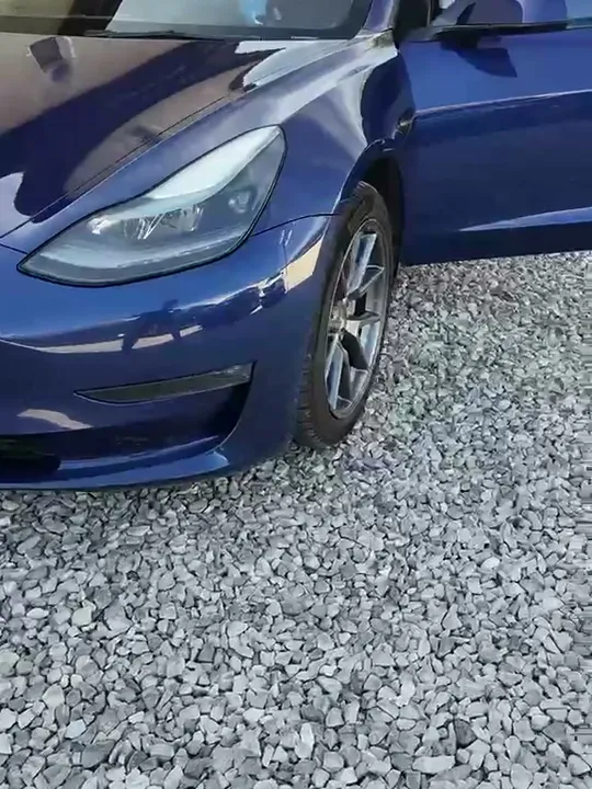 Predná časť modrej Tesly na štrkovej ploche